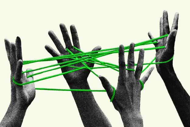 Black-and-white photograph of multiple hands interlaced by a bright green cord forming a network